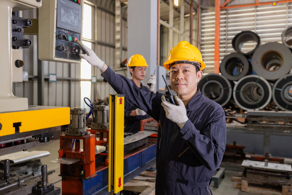 Factory engineers control machinery to produce quality zinc sheet metal.