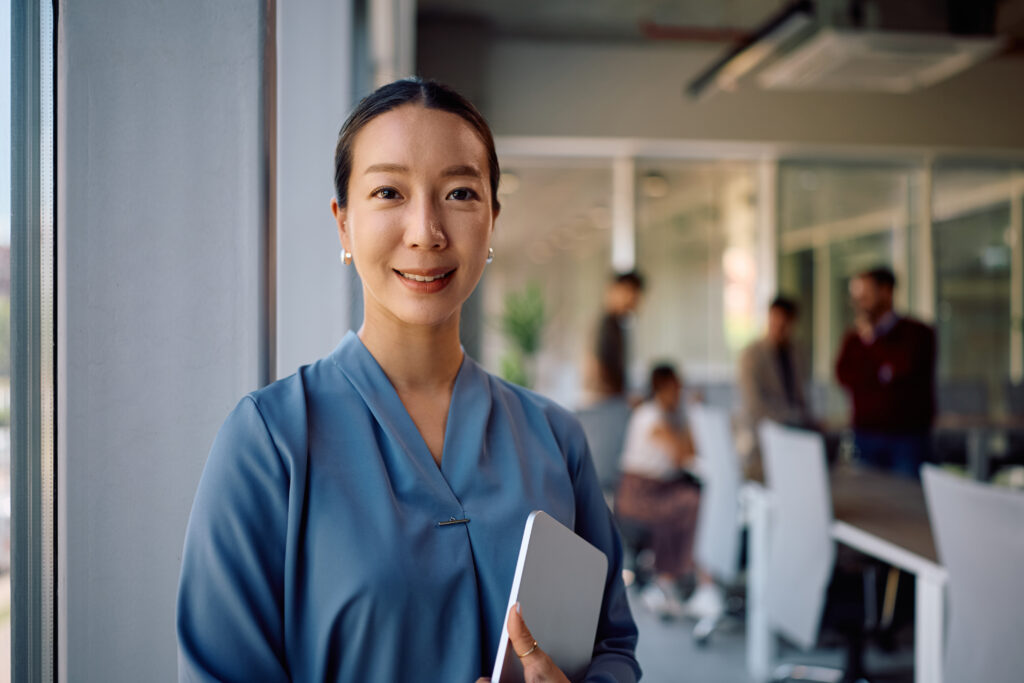 Portrait of smiling korean businesswoman in the office looking at camera.