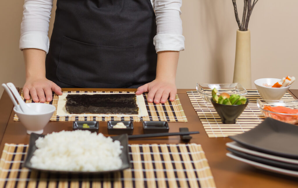 Woman chef ready to prepare japanese sushi rolls